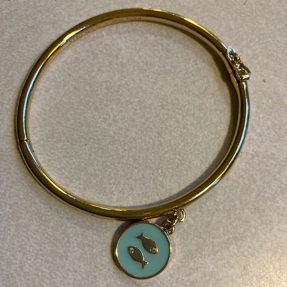 Kate Spade gold toned hinged bangle with enamel fish charm. Hardly worn.